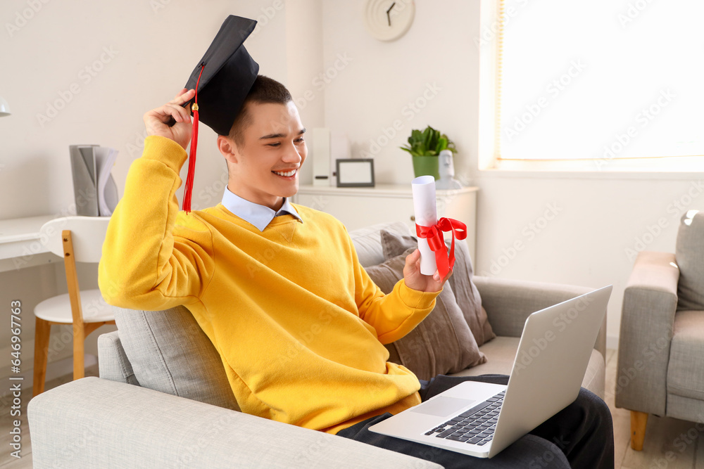 Canvas Prints Male graduate student with diploma and laptop video chatting at home