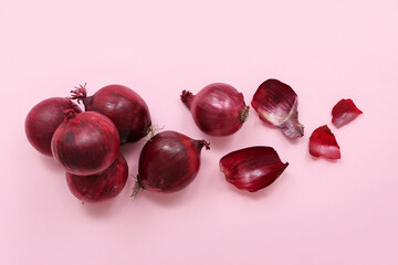 Fresh red onions on pink background