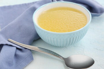 Bowl of tasty vegetable broth on light background