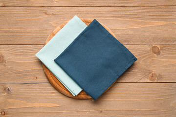 Kitchen board and clean napkins on wooden background