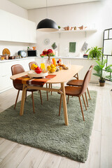 Served dining table on stylish carpet in modern kitchen