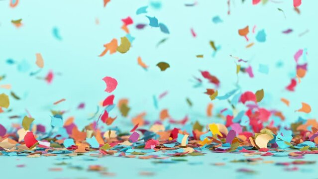 Birthday Confetti Falling on Pastel Blue Background. Super Slow Motion, 1000 FPS.