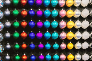 Multi-colored New Year's balls hang neatly in a row.