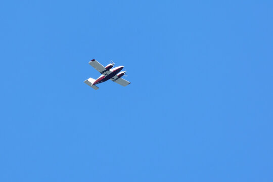 A twin-engine plane flying in a blue sky. Transportation. Aircraft. Leisure.