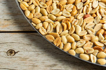 top view of a baking dish with shelled and salted roasted peanuts