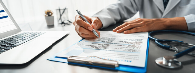 Doctor carefully review detailed medical report with laptop and diagnosing illness for effective...