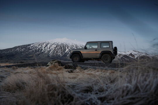 Snaefellsnes, Iceland - December 24th 2022: Suzuki Jimny 4x4 offroader in front of a snow covered volcano on the ring road