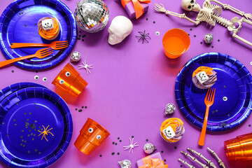 Frame made from Halloween party table setting on purple background
