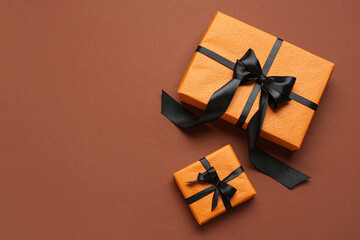 Gifts for Halloween celebration on color background