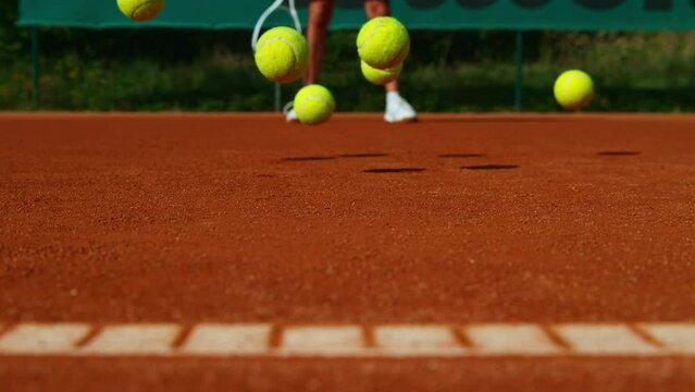 Super Slow Motion Shot of Tennis Balls Hitting a Clay Court at 1000fps.