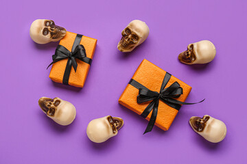 Composition with gift boxes and sculls for Halloween celebration on color background