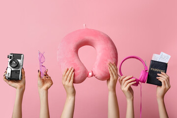 Female hands holding summer accessories on pink background