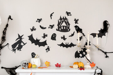 Mantelpiece with pumpkins, fallen leaves, candles and Halloween decor in living room
