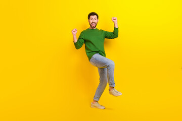 Fototapeta na wymiar Full length body photo of funny overjoyed young man fists up celebrate his championship promotion isolated on yellow color background
