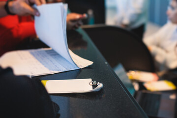 Process of checking in on a conference congress forum event, registration desk table, visitors and attendees receiving a name badge and entrance wristband bracelet and register electronic ticket