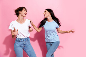 Photo two careless girls dancing party have fun positive good mood shopaholic black friday advert promo isolated on pink color background