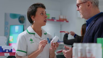 Qualified pharmacist in chemist shop offering patient heart arrhythmia medication pills to treat disease symptoms. Aged man receiving heart attack prevention drug from drugstore worker