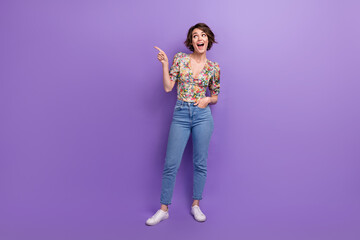 Full length photo of lovely young lady excited point empty space dressed stylish flower print garment isolated on purple color background