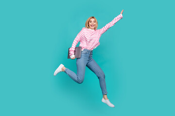 Fototapeta na wymiar Full length photo of shiny pretty girl dressed striped sweater holding modern gadget jumping high isolated teal color background