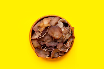 Black fungus mushroom on yellow background.