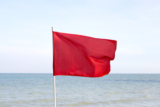 A red flag. Warning sign on the beach