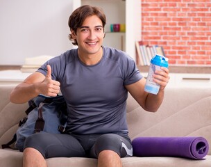 Young handsome man doing sport exercises at home