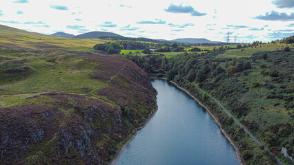Fototapeta na wymiar Nature in Scotland: Torduff Reservoir aerial view. A small elongated reservoir retained by an earth embankment dam in the City of Edinburgh.