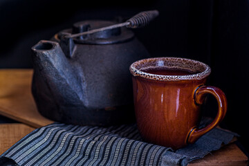 Antique kettle with a cup in low key.
