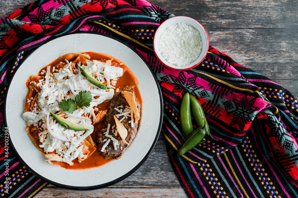 Wall mural Mexican chilaquiles food with spicy red sauce, chicken and avocado traditional breakfast in Mexico Latin America - Wall murals