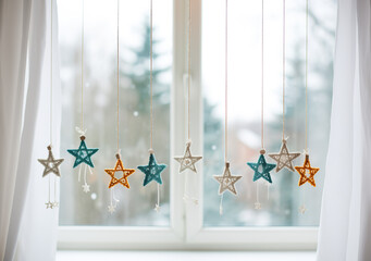 Background of stars hanging in a window. Stars decorated on string in a soft style and blurred details. Festive date celebration.