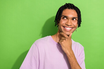 Fototapeta premium Photo of cheerful dreamy guy wear pink t-shirt arm chin looking empty space isolated green color background