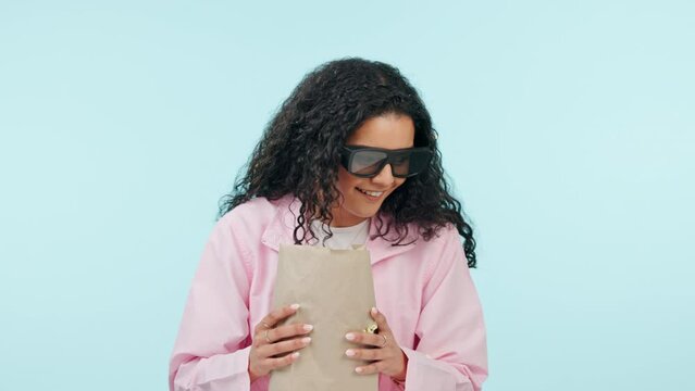 Mockup space, movie and woman with popcorn, eating and scared on a blue studio background. Face, person and model with a snack, film and sunglasses with video, wow and chilling with food and cinema