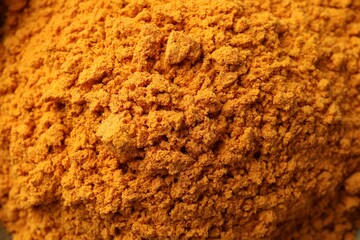 Aromatic turmeric powder as background, closeup view