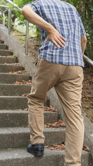 階段で息切れ・腰痛の男性　イメージ