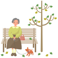 秋の公園で仔犬を連れてベンチに座っているシニア女性