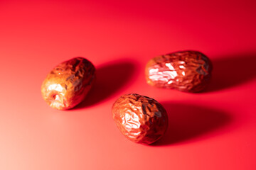 Red dates(jujube) on a red background, concept of healthy diet