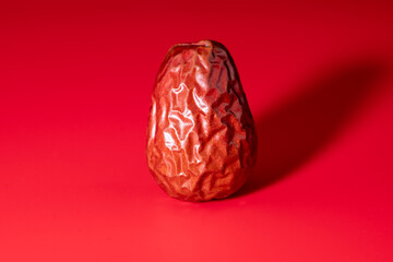 Red dates(jujube) on a red background, concept of healthy diet