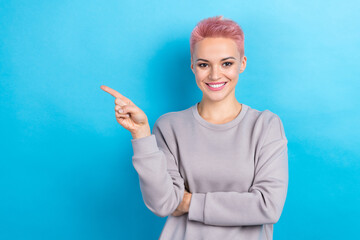 Photo of positive pretty girl wear grey sweatshirt presenting blank space modern technology device shop isolated on blue color background