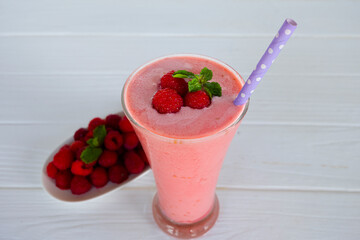 Raspberry smoothie red colorful fruit juice milkshake blend beverage healthy high protein the taste yummy In glass drink episode morning on white wood background from top view.
