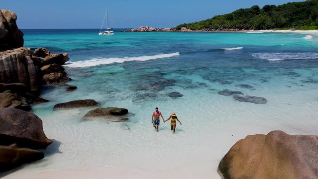 Anse Cocos beach la Digue Seychelles, a couple of men and women on a tropical beach during a luxury vacation at the Islands of Seychelles. white tropical beach near Petite Anse La Digue