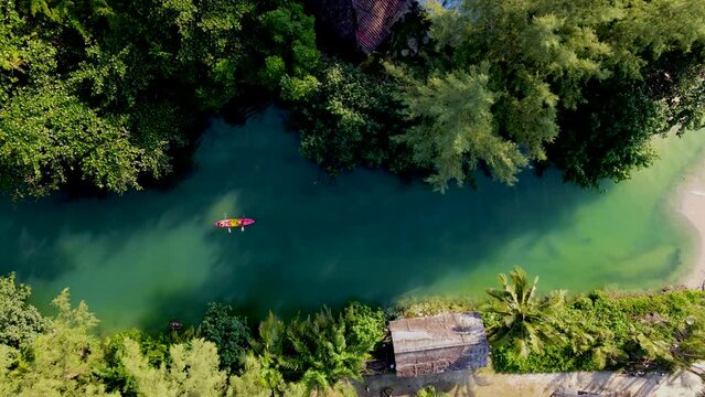 a couple of men and women in a kayak on the tropical island Koh Chang Thailand, drone view at the kayak in a tropical river in the jungle forest of Koh Chang during sunset