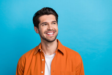 Photo of cheerful nice person beaming smile look interested empty space brainstorming isolated on blue color background
