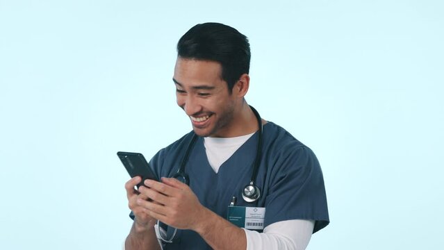 Happy asian man, phone and doctor in good news, winning or celebration against a studio background. Excited male person, medical or healthcare nurse with fist pump or mobile smartphone in achievement