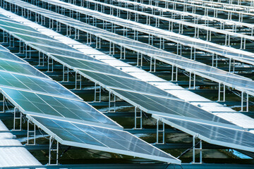 Side view of solar panels floating on water in a lake, for generating electricity from sunlight, selective focus, soft focus.