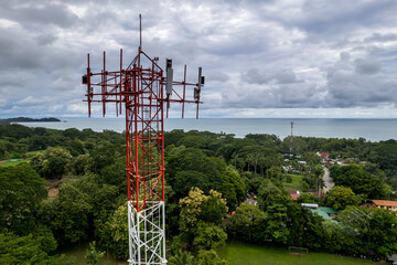 Close up aerial footage of a Cellular, telecommunications, g5 tower in the Mountain and beach of...