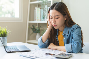 Financial owe asian woman sitting stressed by calculate expense at home, looking at invoice or bill, have no money to pay, mortgage or loan. Debt, bankruptcy or bankrupt concept