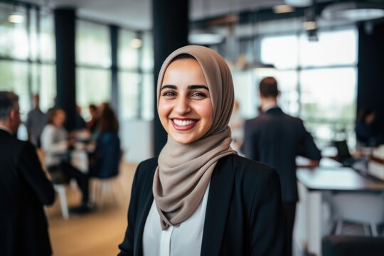 Smiling portrait of a businesswoman of arab descent wearing a hijab working in a startup company in a modern business office