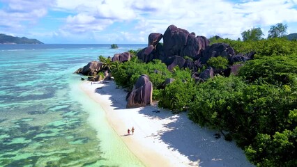 Anse Source d'Argent, La Digue Seychelles, tropical beach during a luxury vacation in Seychelles. Mature couple of men and women walking on the beach , Tropical beach Anse Source d'Argent, La Digue