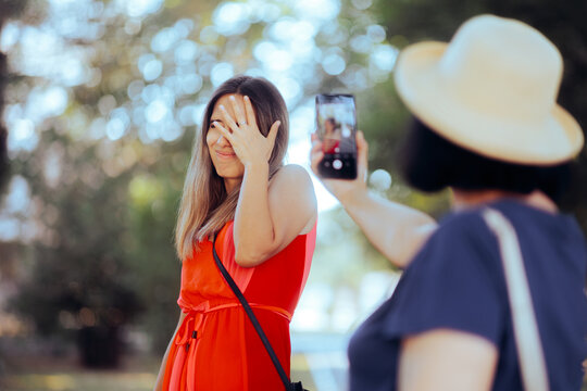 Woman Hiding her Face from Someone Filming Her in Public. Stressed person feeling uncomfortable with being photographed 
