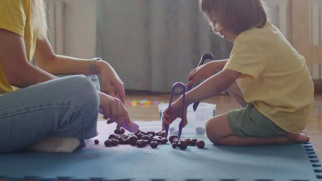 A skilled pedagogue guides a happy child through speech therapy, making learning fun and engaging.